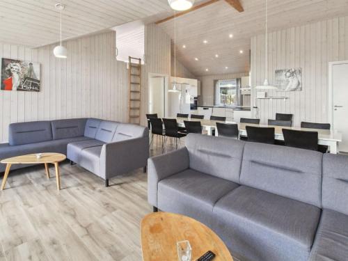 a living room with blue couches and a dining room at Holiday Home Blaga - all inclusive - 3-3km from the sea by Interhome in Rømø Kirkeby