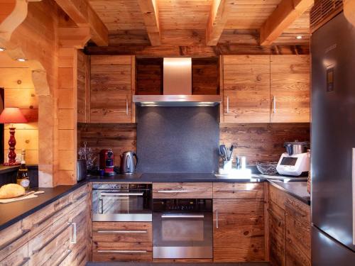 - une cuisine avec des placards en bois et une cuisinière dans l'établissement Chalet Chalet Nirvana by Interhome, à Chesières