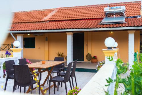 a patio with a table and chairs on a house at Loutra Holiday House in Petrití