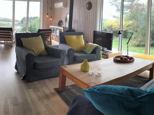 ein Wohnzimmer mit 2 Stühlen und einem Couchtisch in der Unterkunft Holiday Home Stygg - all inclusive - 400m from the sea by Interhome in Knebel