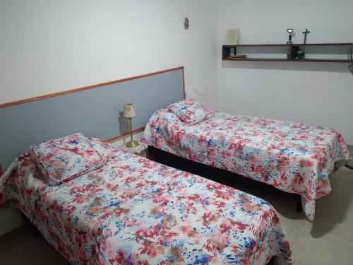 two beds in a small room with a bedspread at Queto in Santa Fe