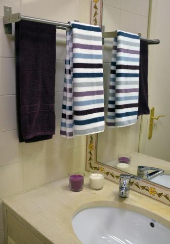 a bathroom with a sink and a mirror and towels at Exciting Beach Villa in Charneca