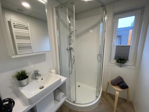 a white bathroom with a shower and a sink at Holiday Home Tiny Haus Marion by Interhome in Riedenburg