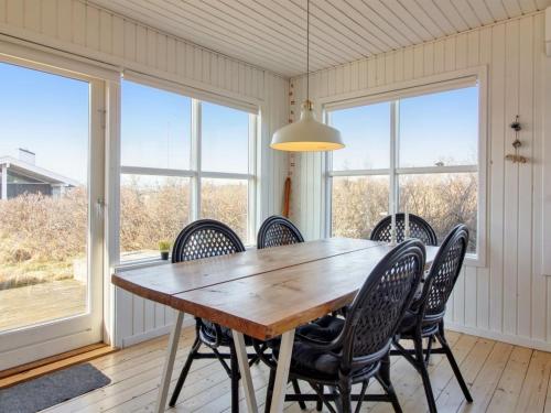 a dining room with a wooden table and chairs at Holiday Home Carstina - all inclusive - 400m from the sea by Interhome in Skagen