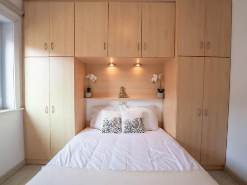 una camera con letto bianco e armadi in legno di Apartment Green Garden-11 by Interhome a De Haan