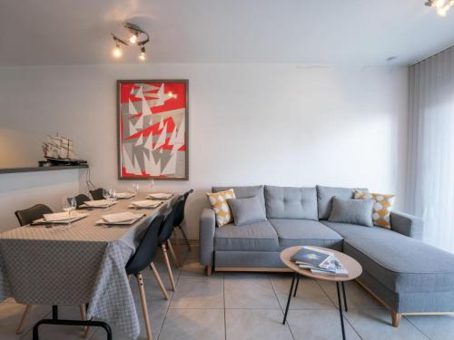 un soggiorno con un divano blu e un tavolo di Apartment Green Garden-11 by Interhome a De Haan