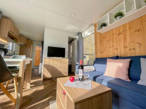 a living room with a blue couch and a table at Holiday Home Tiny Haus Auszeit by Interhome in Riedenburg