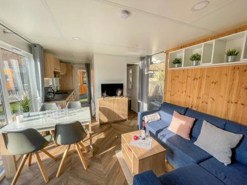 a living room with a blue couch and a table at Holiday Home Tiny Haus Auszeit by Interhome in Riedenburg