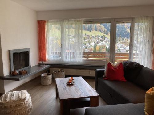 - un salon avec un canapé et une grande fenêtre dans l'établissement Apartment Haus Bettina Fischer by Interhome, à Churwalden