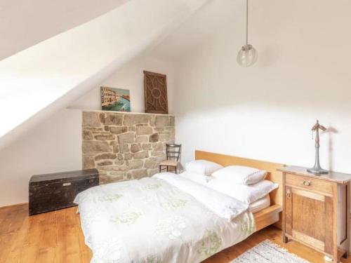 um quarto com uma cama e uma parede de pedra em Holiday Home Kunějov by Interhome em Člunek