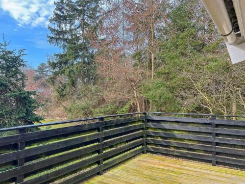 a wooden porch with a fence and trees in the background at Holiday Home Betti - all inclusive - 700m from the sea by Interhome in Vester Sømarken