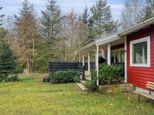 uma casa vermelha com um alpendre e um quintal em Holiday Home Betti - all inclusive - 700m from the sea by Interhome em Vester Sømarken