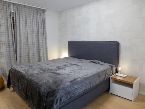 een slaapkamer met een bed en een bijzettafel bij Apartment Elysée by Interhome in Crans-Montana