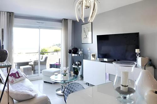 a living room with a couch and a tv at Appartement charmant à Mandelieu-la-Napoule - 50 m² - avec piscine in Mandelieu-la-Napoule