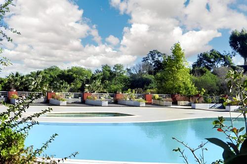 une grande piscine dans un parc arboré dans l'établissement Appartement charmant à Mandelieu-la-Napoule - 50 m² - avec piscine, à Mandelieu-la-Napoule