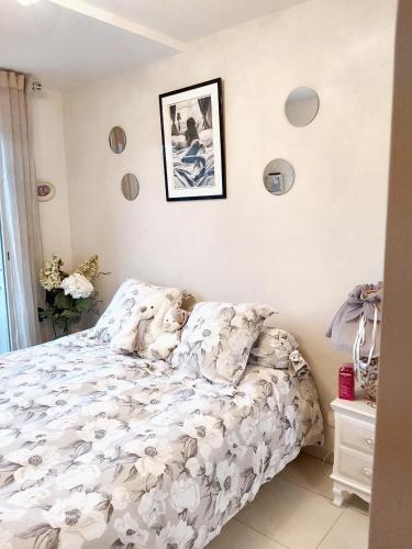 une chambre avec un lit avec un couvre-lit fleuri dans l'établissement Appartement charmant à Mandelieu-la-Napoule - 50 m² - avec piscine, à Mandelieu-la-Napoule