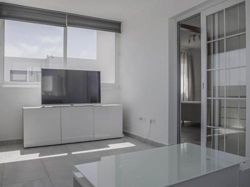 a white living room with a television on a cabinet at Villa Villa Marina by Interhome in Playa Blanca