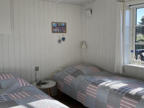 1 dormitorio con 2 camas, mesa y ventana en Holiday Home Suoma - all inclusive - 800m from the sea by Interhome, en Fanø
