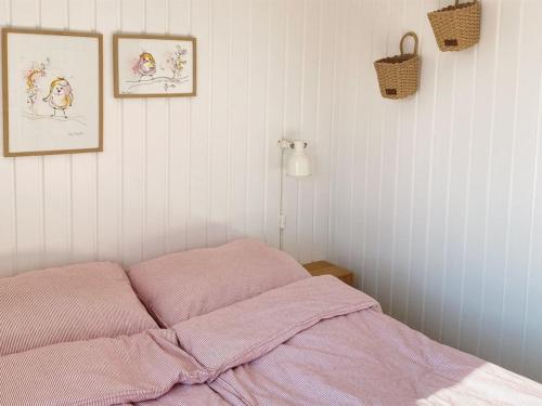 a pink bed in a bedroom with two pictures on the wall at Holiday Home Suoma - all inclusive - 800m from the sea by Interhome in Fanø