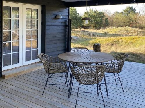 drewniany taras ze stołem i krzesłami w obiekcie Holiday Home Suoma - all inclusive - 800m from the sea by Interhome w mieście Fanø