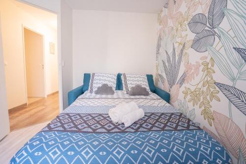 a bedroom with a blue bed with two cats on it at Le Contemporain ~ T4 Spacieux ~ RER A & Disney in Torcy