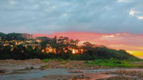 a sunset over a river with trees at Casa Campestre San Joaquin in Restrepo
