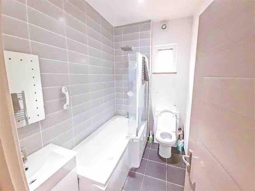 Baño blanco con aseo y lavamanos en London 2 bed apartment, en Woolwich