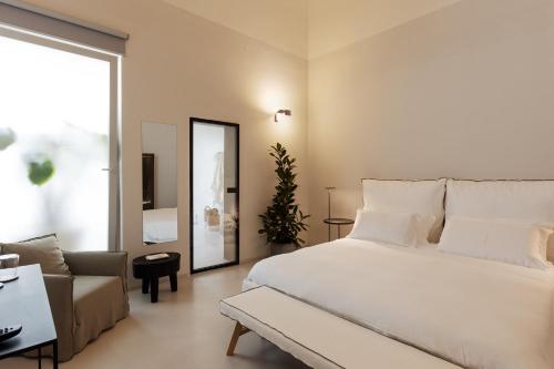 a bedroom with a large white bed and a couch at Palazzo Console in Lecce