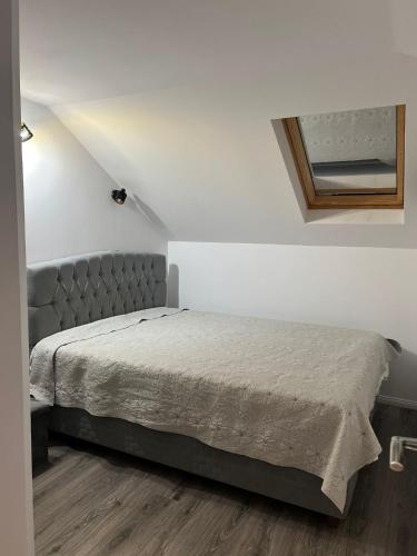 a bedroom with a bed in a white room at Apartament Mansarda Venus in Râmnicu Vâlcea