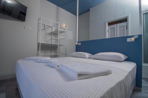 a blue and white bedroom with a bed with pillows at Ocean Dreams in Palaiochóra