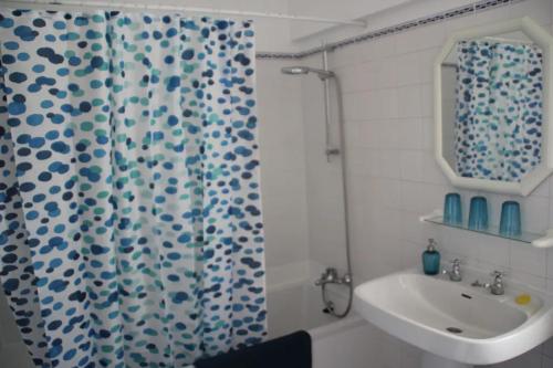y baño con cortina de ducha y lavamanos. en Dream Holidays with See View - Praia Rocha, en Portimão