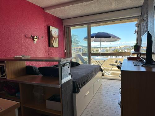 une chambre avec un lit, un bureau et une fenêtre dans l'établissement Village naturiste - Port-Nature 6 - Le Phare, au Cap d'Agde