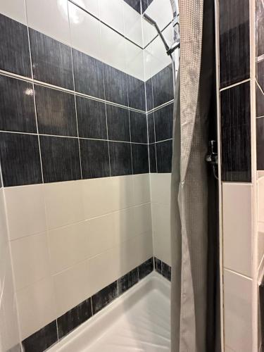 La salle de bains est pourvue d'une douche et de carrelage noir et blanc. dans l'établissement Village naturiste - Port-Nature 6 - Le Phare, au Cap d'Agde