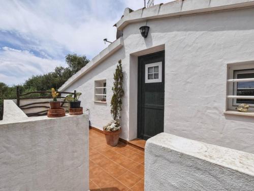 a white house with a black door on a patio at Villa Tortolas by Interhome in Alaior
