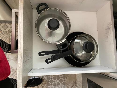 two pots and pans on a shelf in a kitchen at Beach House Málaga in Málaga