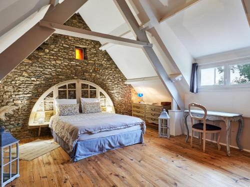 - une chambre avec un lit en face d'un mur en pierre dans l'établissement Holiday Home La Glycine by Interhome, à Glatigny