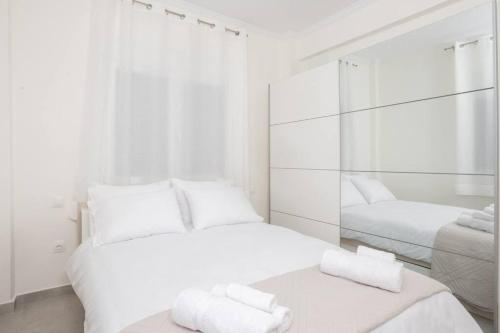 a white room with two beds and a mirror at Zografou House Living in Athens