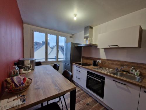 - une cuisine avec une table en bois et un évier dans l'établissement Le Sloop, à Quimper
