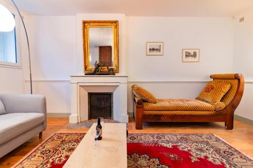 un salon avec un canapé et un miroir dans l'établissement La petite conciеrgeriе du Grand-Rond, à Toulouse