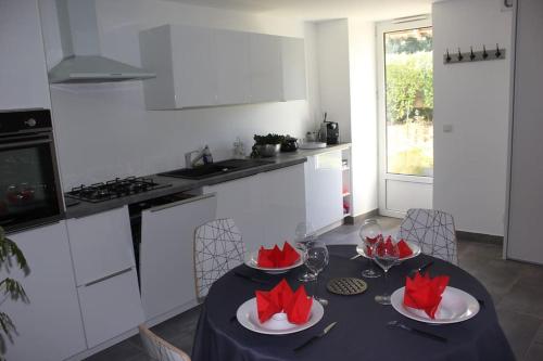 - une cuisine avec une table et des archets rouges dans l'établissement Superbe maison dans un ancien moulin de lignan, à Lignan-de-Bordeaux