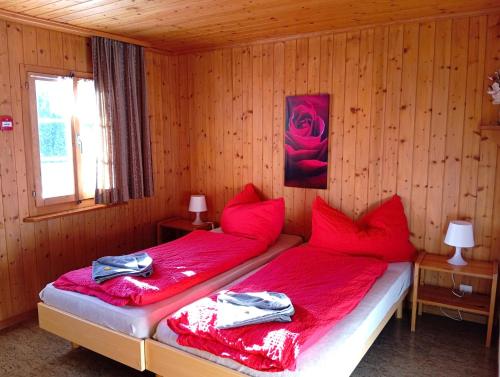 1 dormitorio con 2 camas individuales y sábanas rojas en Chambre double Doppelzimmer Camping Jaunpass, en Boltigen
