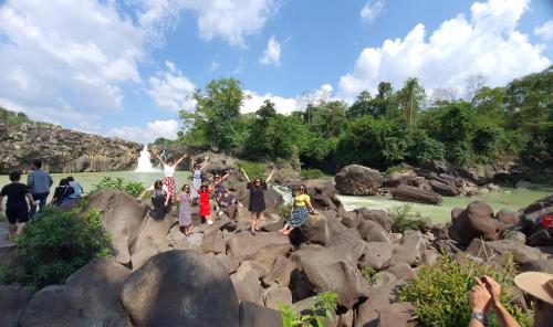 a group of people standing on rocks in front of a waterfall at Nhà nghỉ Minh Quảng in Hanoi