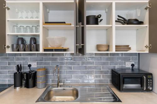 a kitchen counter with a sink and a microwave at Wembley Luxury 3 Bedroom in London