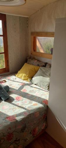 Cama en habitación pequeña con ventana en La Caravana de Sara, en Rincón de la Victoria
