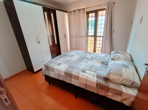 um quarto com uma cama num quarto com uma janela em Sobrado Com Piscina proximo aeroporto em Campo Grande