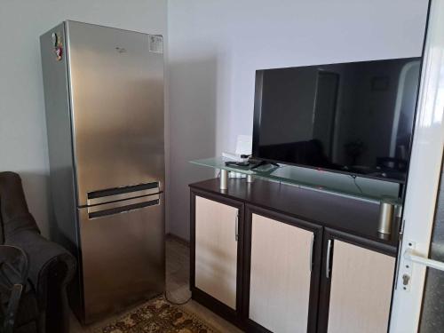 a kitchen with a stainless steel refrigerator and a tv at Zoev in Plovdiv