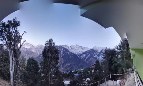 a view of a mountain range from a window at Rudra homestays in Kalpa