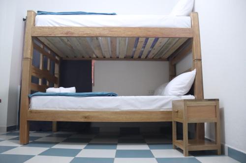 2 Etagenbetten in einem Zimmer mit einem karierten Boden in der Unterkunft CASA KUWA in Mutatá
