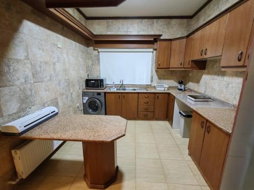 een kleine keuken met een wastafel en een fornuis bij CMK Housing in Madaba