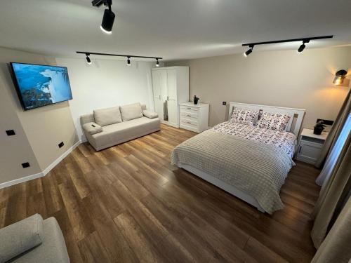 1 dormitorio con 1 cama y 1 sofá en Gray Apartment 24h - Parking, en Katowice